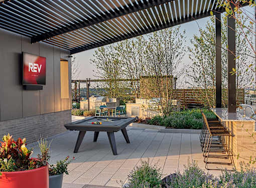 A patio with a table and chairs and a sign that says REV.
