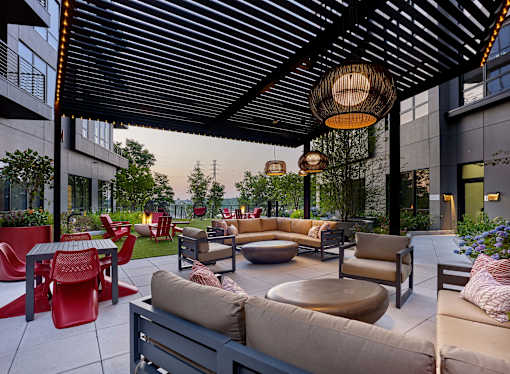 A patio with a variety of seating options including couches, chairs, and tables.