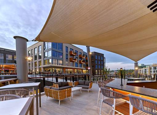 outdoor mezzanine with bar area and lounge seating, outdoor fireplace and tv