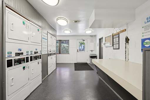 A long hallway with a series of lockers on the left and a bench on the right.