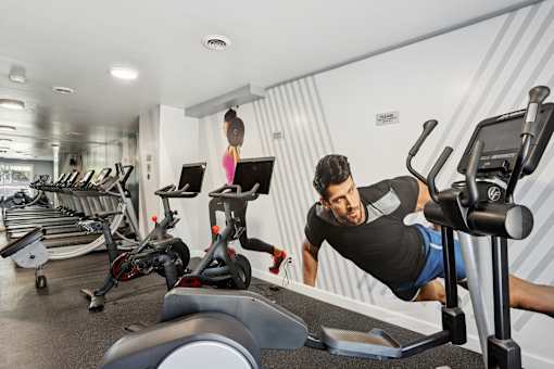 A man is working out on a chest press machine in a gym.