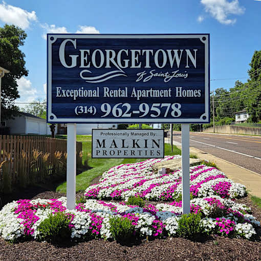 A blue sign for Georgetown Exceptional Rental Apartment Homes with a phone number and the name Malkin Properties.