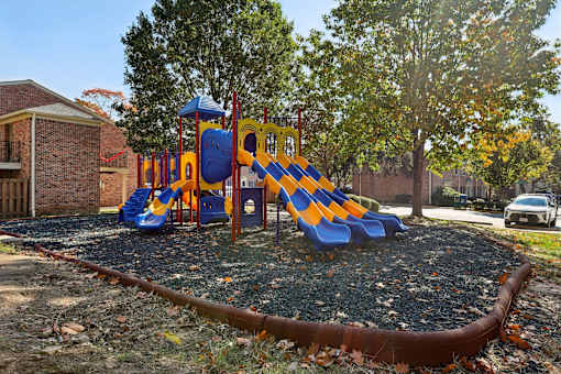 A playground with a blue and yellow slide.
