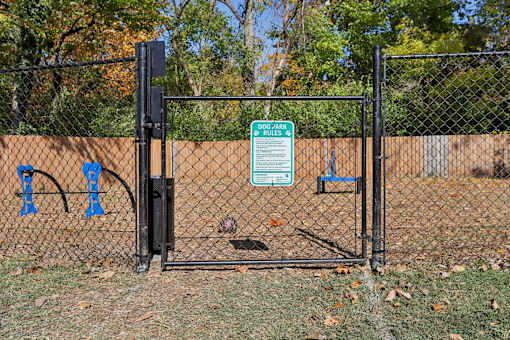 A black fence with a sign that says "DOG PARK" on it.