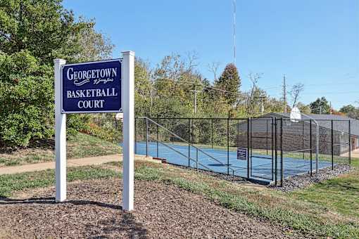 A sign for Georgetown Basketball Court stands in front of a basketball court.