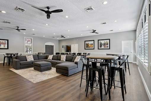 A modern living room with a dark wood floor and a white ceiling with multiple ceiling fans.