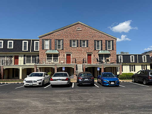 Georgetown Apartments of St. Louis brick building with second-floor balconies and parking lot.