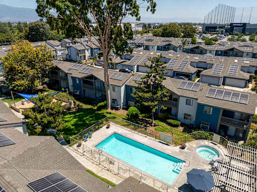 A townhome community with a pool and solar panels next to Top Golf.