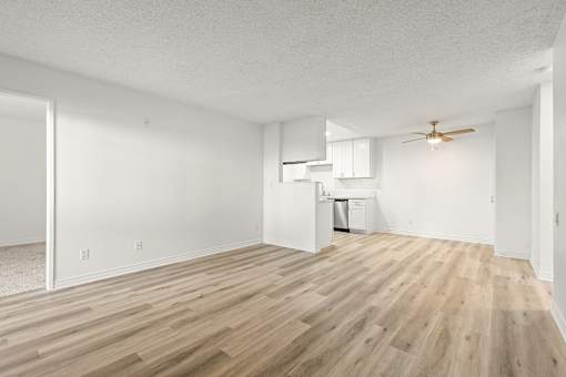 A room with wooden flooring and white walls.