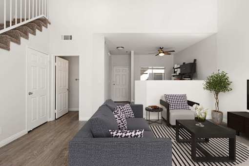 A living room with a grey couch and a black and white striped rug.