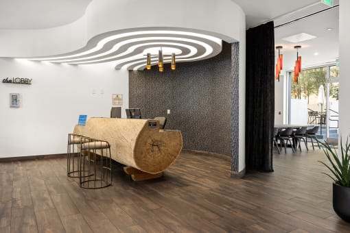 a reception area with a wooden desk and chairs and a spiral design on the ceiling