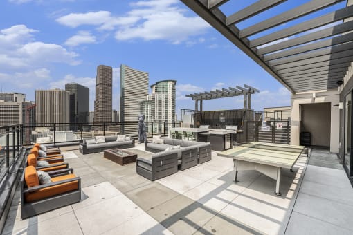 a rooftop patio with furniture and a view of the city