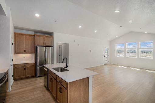 A kitchen with wooden cabinets and a stainless steel refrigerator.