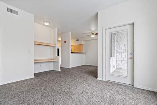 A room with a white door, a window, and a ceiling fan.