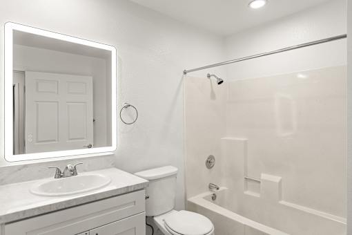 A white bathroom with a sink, toilet, and bathtub.