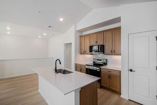 A kitchen with a white counter top and wooden cabinets.