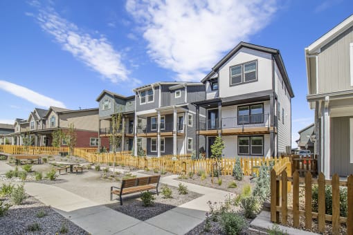 a group of townhomes with benches in a courtyard