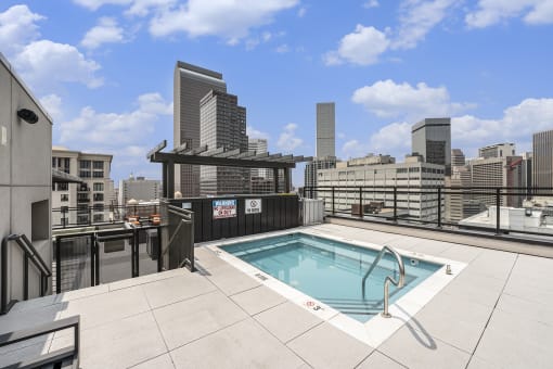 a rooftop pool with a city skyline in the background