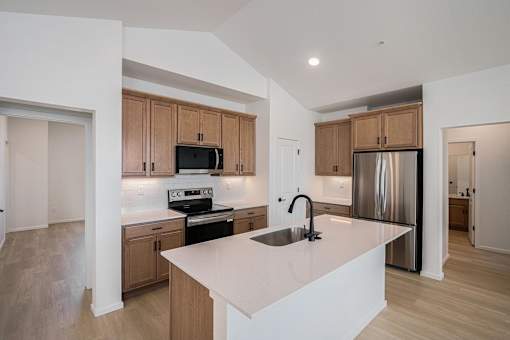 A kitchen with a white counter top and wooden cabinets.