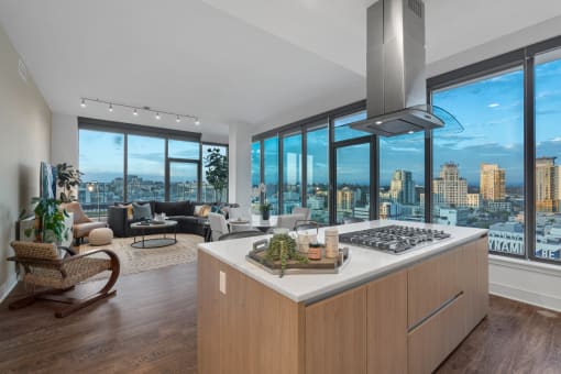 a kitchen with a large island in front of a window with a city view at Stanza Little Italy, San Diego, CA, 92101