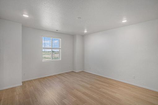 A room with a window and wooden flooring.