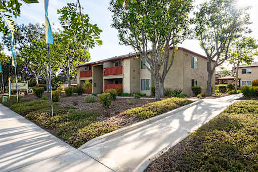 A sunny day at a residential area with apartment buildings and a sidewalk.