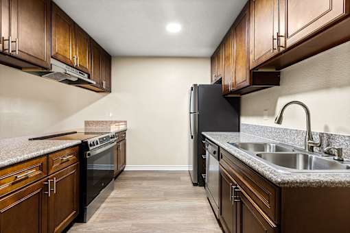 A kitchen with brown cabinets and black appliances.