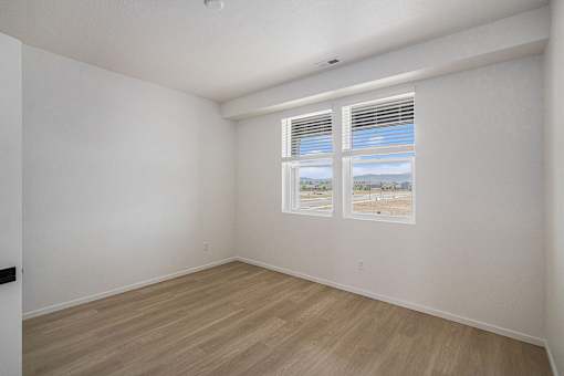 A room with a window and a wooden floor.
