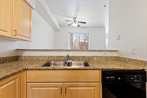 A kitchen with wooden cabinets and granite countertops.