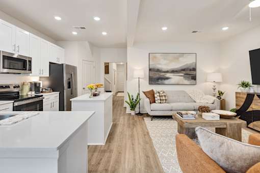 A modern kitchen with a long wooden table in the middle of the room.