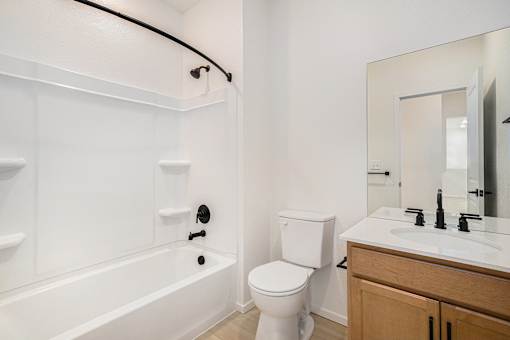 A white bathroom with a toilet, sink, and bathtub.
