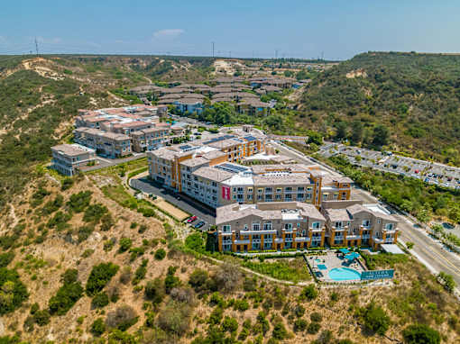 A large building complex with a swimming pool in the foreground.
