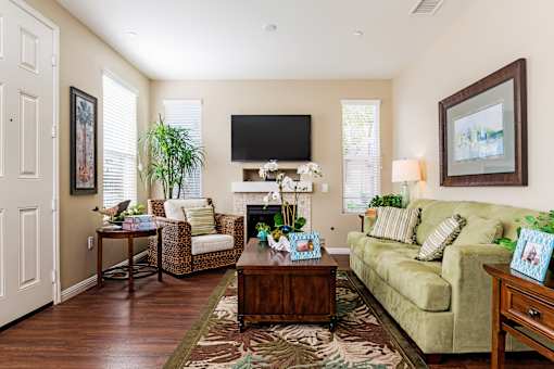 A living room with a couch, chair, and a television.