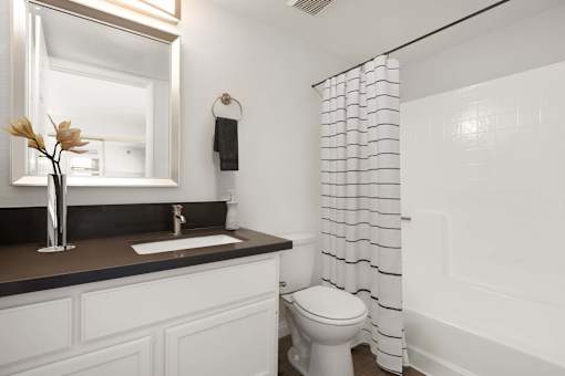 A white toilet sits next to a white sink in a bathroom.