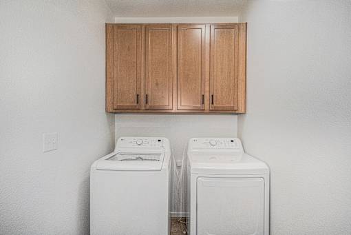 Two white front load washing machines in a laundry room.