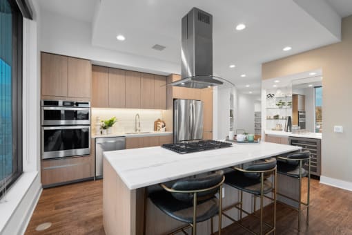 a kitchen with a large center island with three stools at Stanza Little Italy, San Diego, California