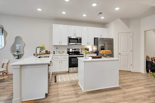 A modern kitchen with white cabinets and appliances.