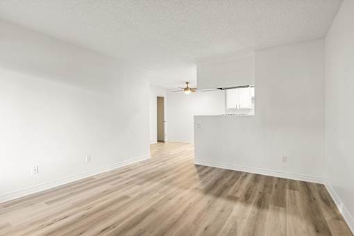 A room with wooden flooring and white walls.