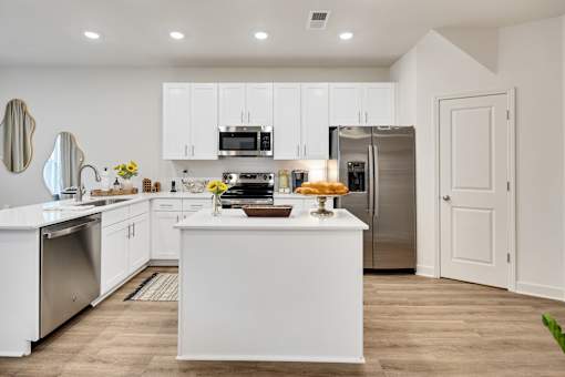 A modern kitchen with white cabinets and stainless steel appliances