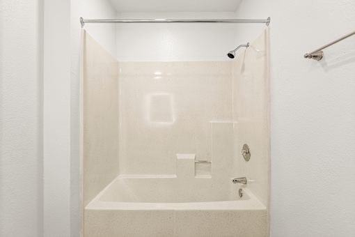 A white bathroom with a glass shower door.