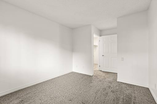 A room with a carpeted floor and a white door.