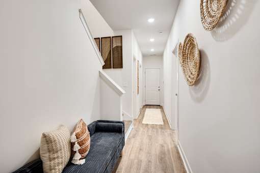 A hallway with a bench and baskets on the wall.