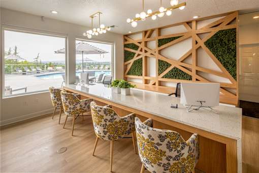 A kitchen with a white counter and yellow chairs.