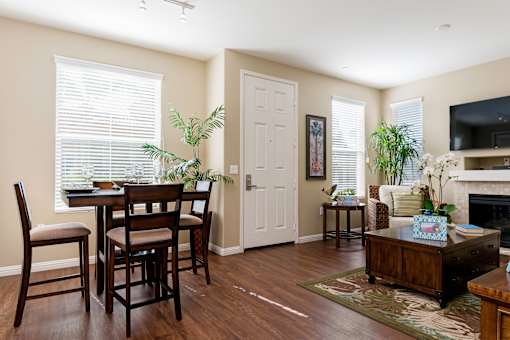 A dining room with a table and chairs.