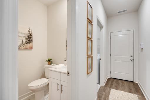 A white bathroom with a toilet, sink, and pictures on the wall