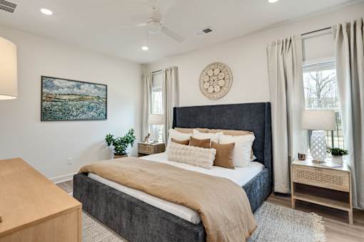 A bedroom with a large bed and a painting on the wall.