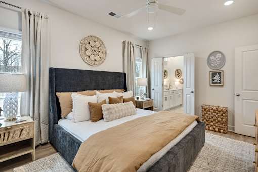 A bedroom with a large bed and a ceiling fan