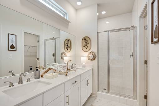 A bathroom with a white sink and a mirror above it