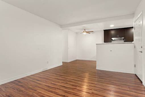 A room with wooden flooring and a ceiling fan.