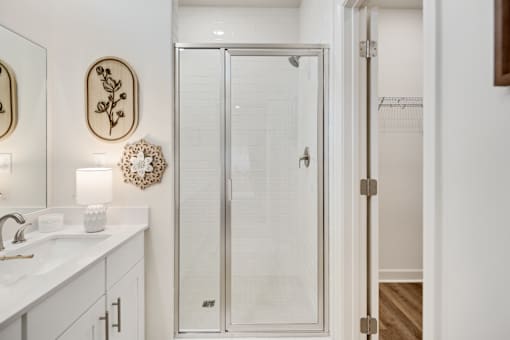 A white bathroom with a glass shower door.
